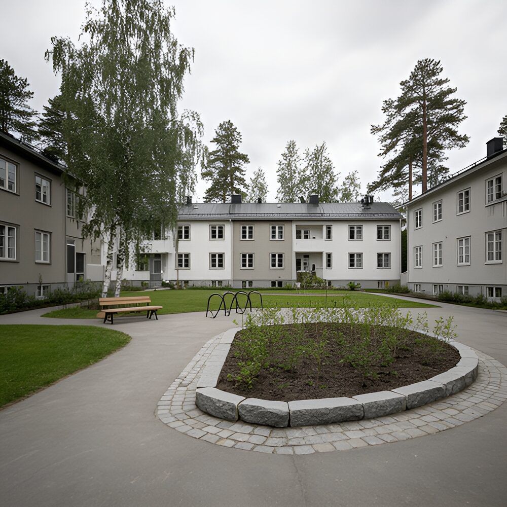 Innergård med plattor, gångväg i smågatsten och planteringar mellan flerbostadshus
